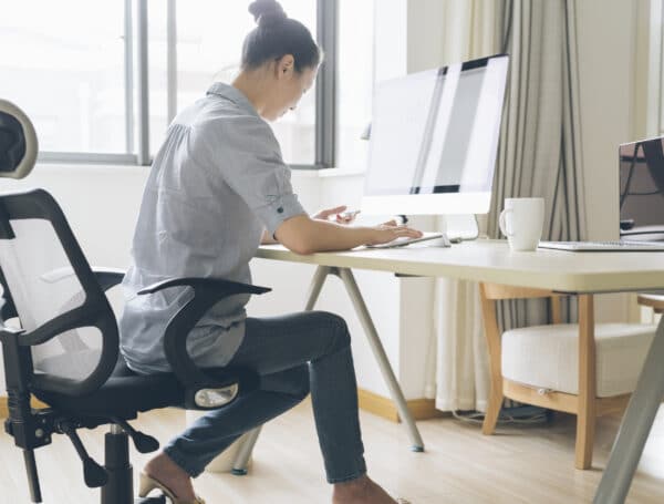 A woman with a bun typing on her computer.