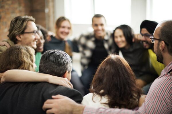 A group of diverse workers doing a group hug