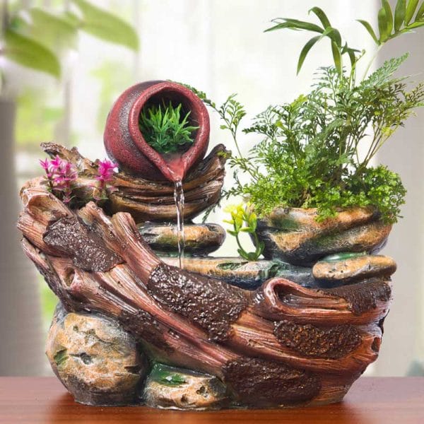 a small fountain with miniature plants on a table