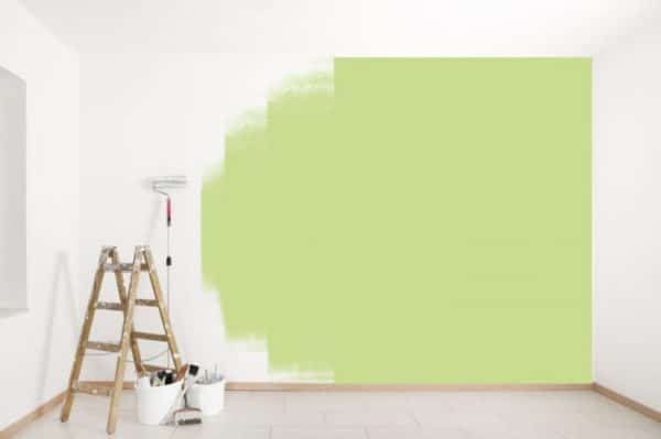 an empty room being painted green with a paint roller