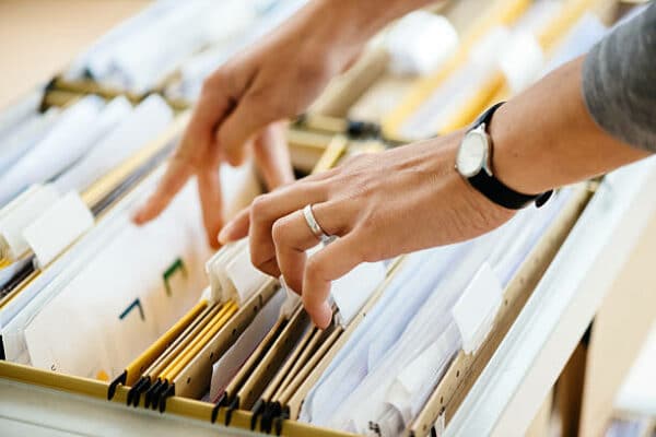a woman going through the files in a file cabinet
