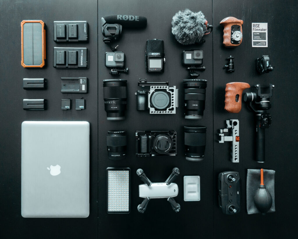 Black background with Camera gear and a mac book pro laptop 