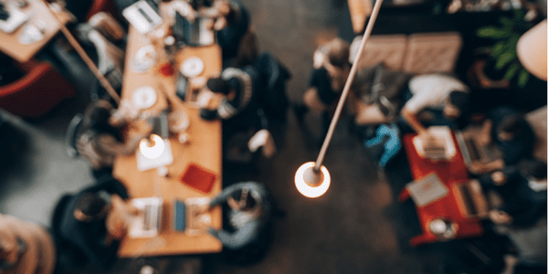 a light bulb hanging over a busy coworking space
