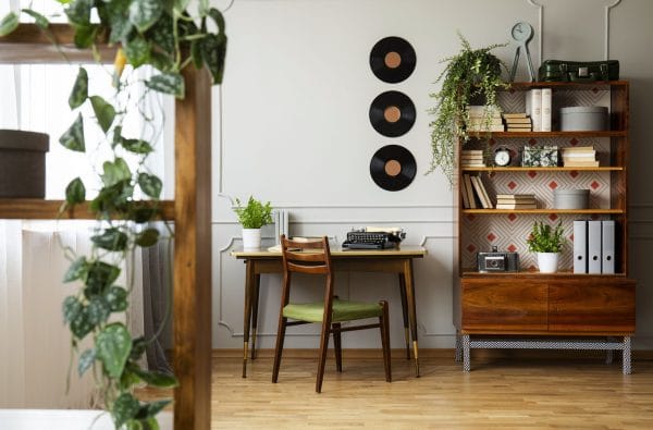 a simple rustic room with wooden furniture and indoor plants