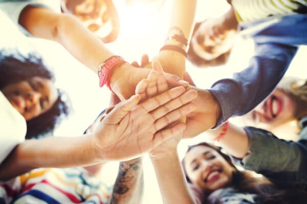 a group of people putting their hands together