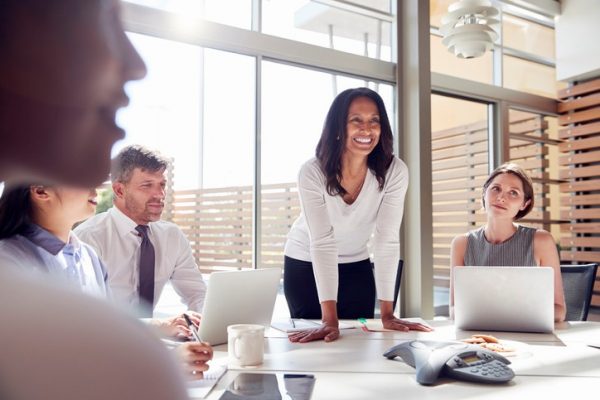 Smiling female manager listening to colleagues at a meeting