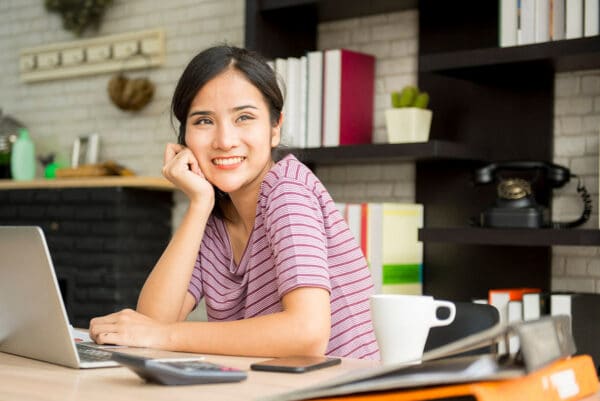 A smiling asian woman sitting down