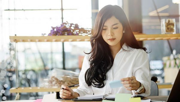 a beautiful asian woman with long hair working