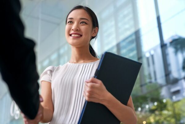 an asian businesswoman shaking her hand