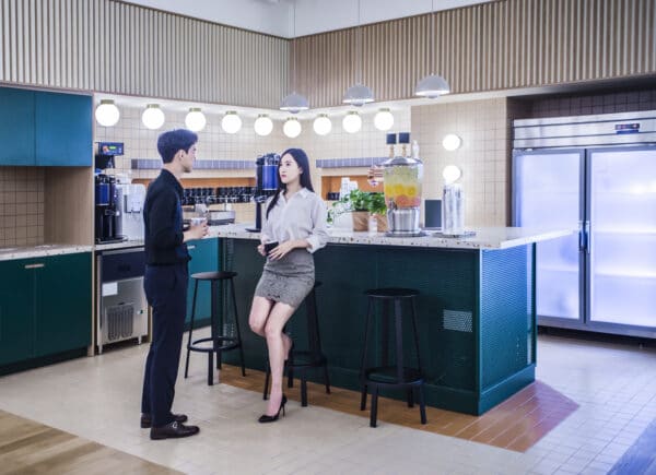 Two office workers talking in the office pantry