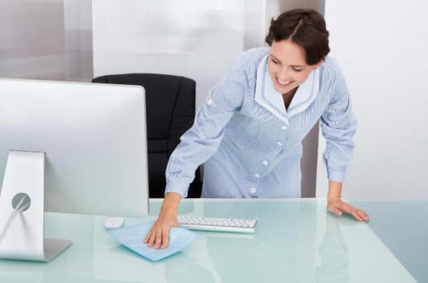 A woman cleaning her office desk