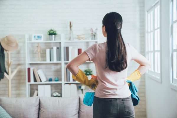 a woman preparing herself to clean and declutter the shelves