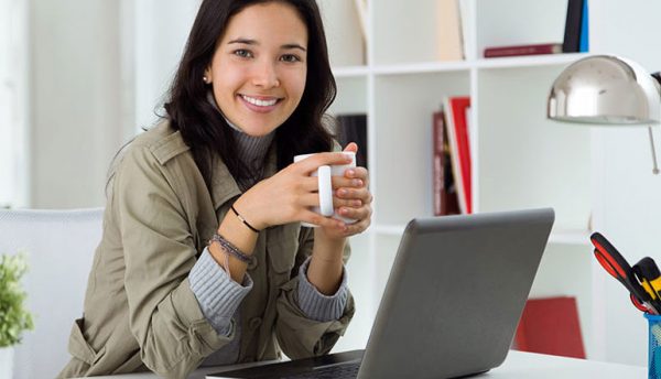 a work-from-home woman enjoying a cup of coffee in her home office