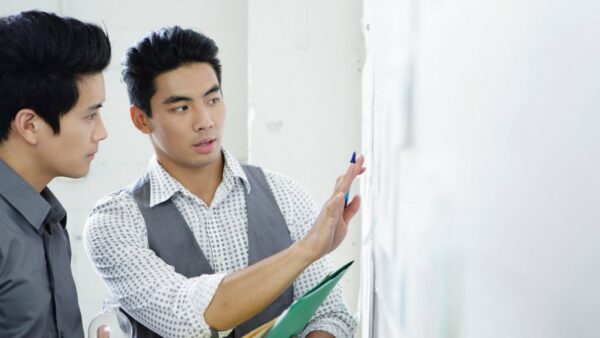 an asian man explaining a problem to his colleague