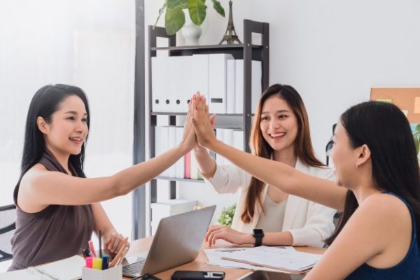 a group of beautiful asian women doing a high five