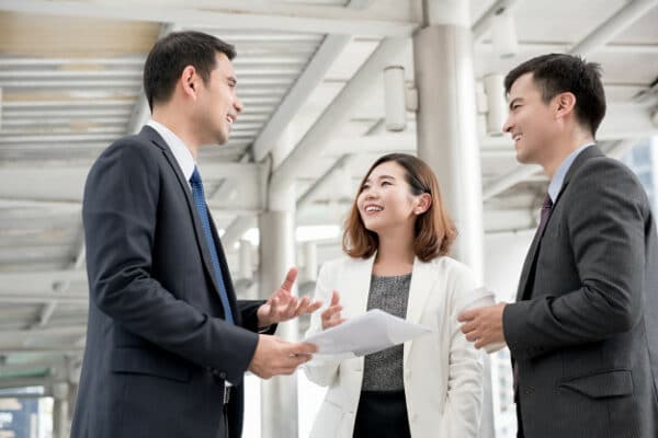 a group of 3 people in the office talking