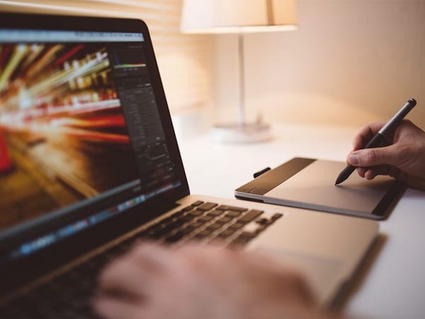 A man using his laptop and touch pad to design
