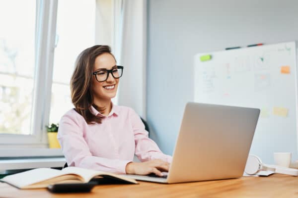 smiling young woman working in office with laptop
