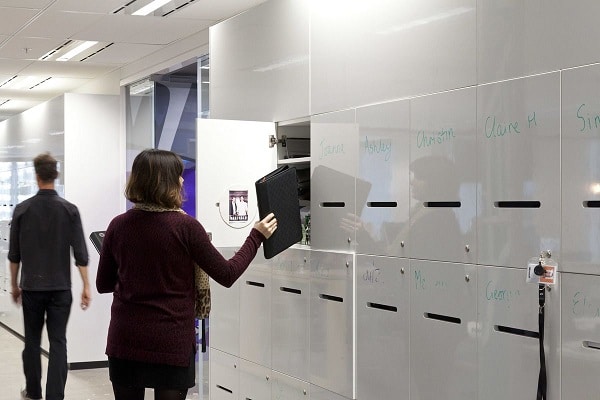 A woman putting a book inside a storage locker