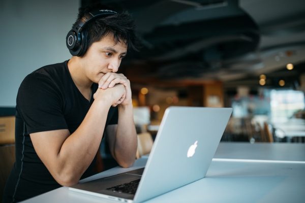 a man watching a video from his laptop with his headphones on