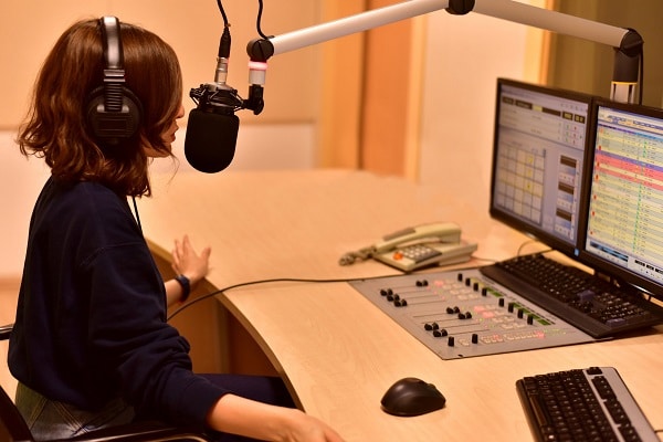 A woman talking on the microphone inside a studio