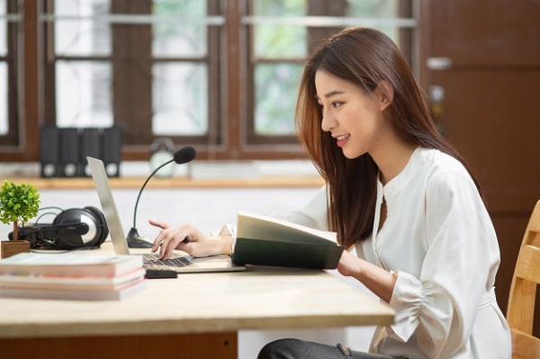 An Asian woman using a laptop