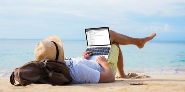 man with laptop on beach
