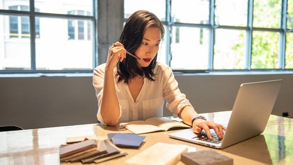 An asian woman using her laptop to work, focused