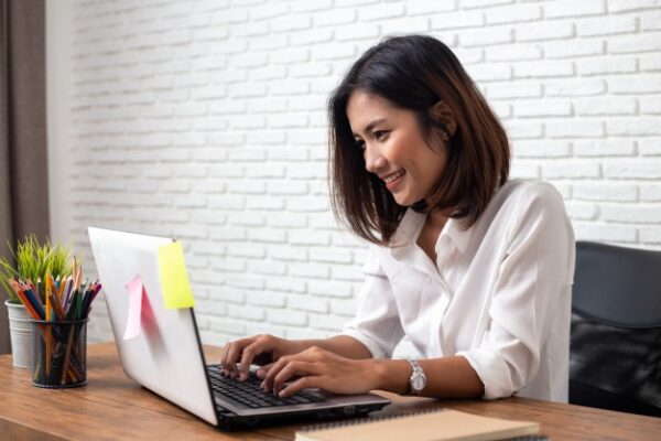 an asian woman working on her laptop