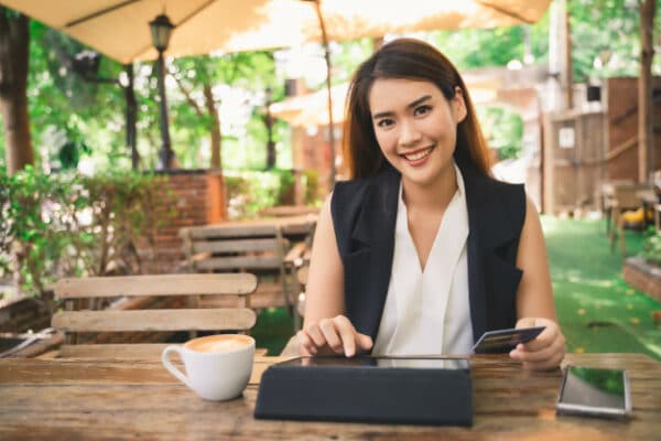 a smiling asian woman having coffee at a cafe